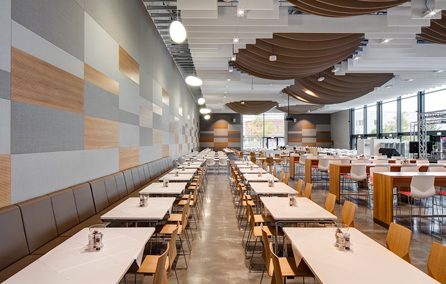 The interior of a canteen with tables and chairs and canteen furniture